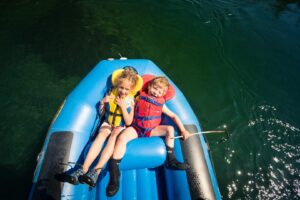 Deux enfants en radeau pneumatique sur la rivière Bonaventure pour faire la descente la familiale